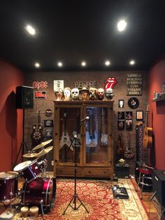 a room filled with lots of musical instruments and guitars on the wall next to a drum set