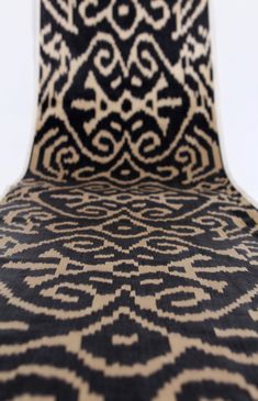 an upholstered chair with black and white designs on it's back end