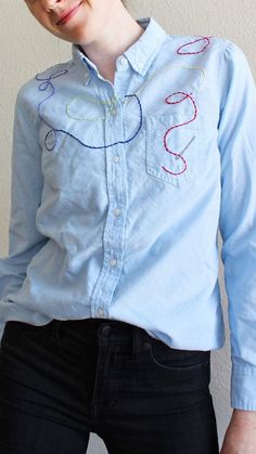 Light blue button-down hand-embroidered with multi-colored thread and needle design. Greenhouse Embroidery, Light Blue Linen Shirt, Light Embroidery, Thread And Needle, Blue Linen Shirt, Plain Shirt, Needle Thread, Thread Embroidery, Needle And Thread