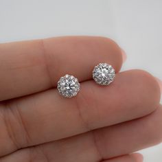 These cubic zirconia stud earrings featuring a pavé halo sparkle so bright! They are so elegant and work great for everyday first-hole studs or as wedding or bridesmaid earrings. Absolutely beautiful! We also use the highest grade of cz for an authentic diamond look! They look like real diamonds 🤩 Made of 925 Sterling Silver We use a THICK plating of 14k Gold or Rhodium Nickel-free & Hypoallergenic (safe for sensitive ears!) Sold as a pair 7mm Diameter Push-back closure 🎁 Comes in a gift-box, Elegant Halo Cubic Zirconia Diamond Earrings, Diamond White Halo Earrings In Cubic Zirconia, Elegant Cubic Zirconia Halo Diamond Earrings, Halo Diamond White Earrings In Cubic Zirconia, Cubic Zirconia Round Cut Cluster Earrings For Wedding, Dazzling Diamond White Earrings With Halo Setting, Dazzling Halo Cluster Earrings, Diamond White Brilliant Cut Cubic Zirconia Bridal Earrings, Sparkling Diamond Cluster Earrings For Anniversary