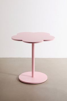 a pink table sitting on top of a cement floor