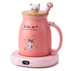 a pink coffee mug with a cat on top