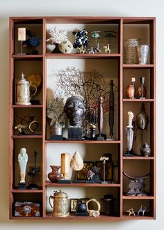 a wooden shelf filled with lots of vases and figurines