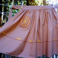 a pink dress hanging on a clothes line with trees in the backgrouds