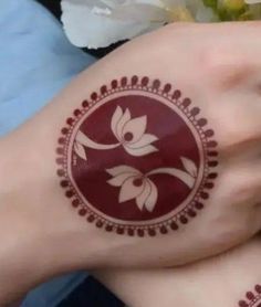 two hands with henna tattoos on their palms and one hand is holding a flower