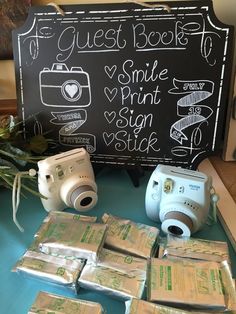 several cameras sitting on top of a table next to some money and a blackboard