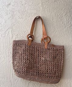 These gorgeous handwoven totes are designed and produced in Cape Town, South Africa.  Each piece is composed from sun dried raffia and leather.  No two are the same,  colors and shape  may slightly vary. Summer Beige Crochet Bag With Intrecciato Weave, Vacation Beige Shoulder Bag With Intrecciato Weave, Beige Crochet Bag With Intrecciato Weave For Beach, Beige Crochet Bag With Intrecciato Weave For Shopping, Beige Intrecciato Weave Crochet Beach Bag, Summer Light Brown Straw Bag With Braided Handles, Beach Crochet Bag With Intrecciato Weave In Straw, Beach Crochet Bag With Intrecciato Weave, Beach Crochet Straw Bag With Intrecciato Weave