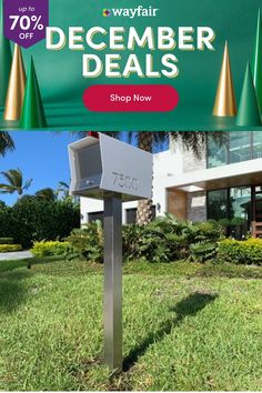 a mailbox sitting in the grass next to a sign that says, wayfair december