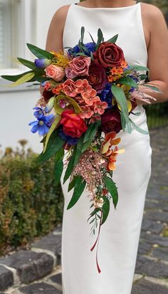 a woman in a white dress holding a bouquet of flowers