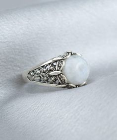 Make a statement with this exquisite Handmade Filigree Art Moonstone Gemstone Women Silver Cocktail Statement Ring. Crafted with intricate details, this ring features a mesmerizing 10 mm cabochon round-cut moonstone gemstone, set in an elegant silver band measuring 0.55 inches / 13.50 mm in length and width. This stunning ring showcases the beauty of filigree, an ancient art form that originated in Mesopotamia and Anatolia. It comes with a silver polish cloth and luxurious gift box, making it th Bohemian Cabochon Moonstone Ring, Intricate Design Moonstone Jewelry, Bohemian Round Cabochon Moonstone Ring, Bohemian Crystal Ring With Moon Phase, Vintage Round Cabochon Moonstone Ring, Elegant White Moon Shaped Ring, Elegant White Moon-shaped Ring, Vintage Cabochon Moonstone Ring, Elegant Adjustable Moon Shaped Crystal Ring