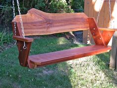 a wooden swing that is in the grass