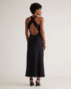 the back of a woman wearing a black dress with an open back and cutout