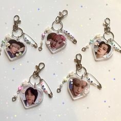 four keychains with pictures of the same person hanging from them on a table