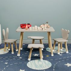 a child's table and chairs in a room with stars on the rugs