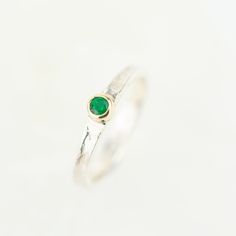 Tess, a beautiful gemstone Storybook ring set with your choice of sparkling gemstone. Featuring a rainbow of birthstone gems, Tess makes the perfect birthday gift. Set with the May birthstone, a beautiful green emerald. The storybook band is textured with the signature Storybook finish, a leather like design reminiscent of well loved and worn books. The edges move up and down organically as the silver gentle flows around your finger. They make the perfect ring worn on their own, or stacked with Adjustable Round Emerald Birthstone Ring, Adjustable Round Emerald Ring As Birthstone, Adjustable Round Emerald Ring With Birthstone, Green Crystal Birthstone Ring In Sterling Silver, Fine Jewelry Sapphire Ring For May Birthstone, Fine Jewelry Emerald Birthstone Ring As Gift, Emerald Gemstones With Accents For Anniversary, Sterling Silver Crystal Ring With Accent Stones For May, Fine Jewelry Stackable Rings For May Birthstone