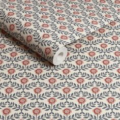 an image of a wallpaper with red and blue flowers on the background, as well as a roll of toilet paper