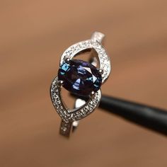 It is a lab alexandrite  ring. The main stone is 6 mm*8 mm oval cut.weight about 1.87 carats.The basic metal is sterling silver and plated with rhodium.To change the metal to a solid gold (white/rose) or platinum is also available, please ask for a quotation if you want.You can also go to my shop Home for more elegant rings: https://www.etsy.com/shop/godjewelry?ref=hdr_shop_menu Alexandrite is June birthstone.More alexandrite rings:https://www.etsy.com/shop/godjewelry?section_id=20715043Customiz Oval Tanzanite Birthstone Ring With Accent Stones, Oval Purple Sapphire Rings, Purple Sapphire Oval Ring, Elegant Oval Tanzanite Birthstone Ring, Tanzanite Oval Birthstone Promise Ring, Oval Tanzanite Birthstone Promise Ring, Color Changing Ring, June Birthstone Ring, Engagement Ring Photos