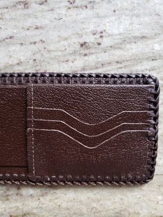 This wallet is tooled using genuine vegetable tanned cowhide and hand laced with calfskin lace. The carving and tooling is done in the Sheridan Style with a rich color stain applied overall. A top finish has been applied to protect your wallet for years of wear. The inside has six pockets for credit cards and I D. A name or initials may be added at no extra charge. Wallet can also be hand saddle stitched upon request. Traditional Bifold Wallets For Everyday Use, Traditional Bifold Wallet For Everyday Use, Hand Tooled Leather Wallet, Hand Tooled Leather Trifold Wallet For Everyday Use, Traditional Brown Wallets For Daily Use, Hand Tooled Brown Wallets As Gift, Leather Trifold Wallet Hand Tooled For Everyday Use, Leather Hand Tooled Trifold Wallet For Everyday Use, Traditional Leather Wallets For Daily Use