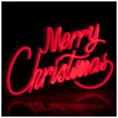 merry christmas neon sign on black background with red light and reflection in the foreground