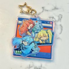 two key chains with cartoon characters on them sitting next to each other in front of a marble counter top