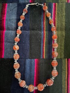 Beautiful Old Himalayan Melon-Cut Carnelian Necklace with handmade White Brass Spacer Beads from Himalayas (Nepal). A carnelian stone symbolizes bold energy, warmth, and a joy that lingers as much as it empowers and stimulates. It's known for being a stone of courage, endurance, energy, leadership, and motivation. Measurements:- Beads size - 12mmx18mm Necklace length- 22.5inches(approximately) Weight- 162 grams  * Colors may vary slightly  in person due to the lighting/flash lighting in photo Traditional Orange Jewelry For Healing, Traditional Orange Healing Jewelry, Silver Carnelian Hand-strung Jewelry, Silver Carnelian Jewelry Hand-strung, Hand-strung Silver Carnelian Jewelry, Traditional Orange Necklace With Natural Stones, Traditional Orange Gemstone Bead Necklaces, Traditional Handmade Carnelian Necklace, Orange Gemstone Beads Jewelry For Festival