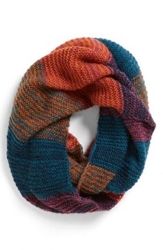 a multicolored knitted scarf with a knot on the end and an open loop