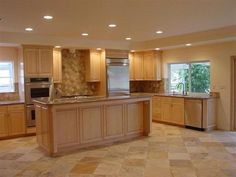 a large kitchen with an island in the middle and lots of cabinets on both sides