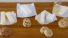 chocolate chip cookies, cheese and milk on a cutting board