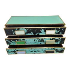 three drawers are stacked on top of each other, one has green and blue paint