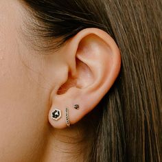 a close up of a person's ear with two piercings on it and one behind the ear