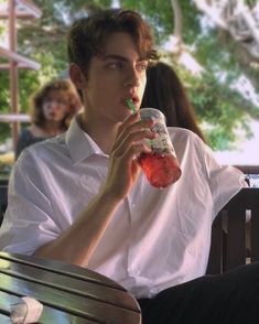 a man sitting at a table with a drink in his hand