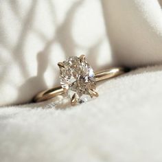 a diamond ring sitting on top of a white cloth