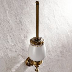 an old fashioned brass wall light with a white glass shade