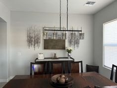 a dining room table and chairs in front of a window