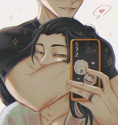 two people are hugging and one is holding a cell phone with the other's face on it