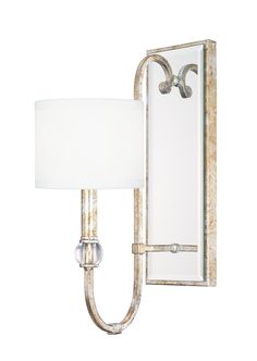 a wall light with a white shade on it's side and a mirror behind it