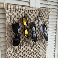 four pairs of sunglasses are hanging on a wall with eyeglasses attached to it