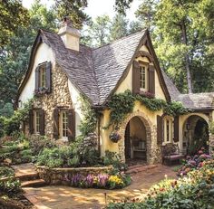 a small house with lots of flowers around it