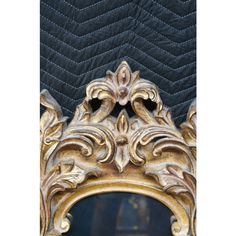 an ornate gold framed mirror on a black velvet background with chevron pattern and decorative details