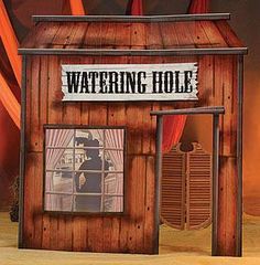 a wooden building with a sign that says watering hole