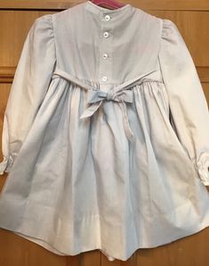 "Grey with long sleeves. Smocked bodice & a lace collar. Elasticsized wrists/2 top back buttons/smoke free environment/only issue(as seen in last picture)A green dot possibly marker on front/no size label/ true vintage. please pay attention to measurements/pit to pit 12\"blouson/waist 11 1/2\"can be tied back with bow sashes/pit to wrist 11\"/length (shoulder to bottom 22\" w/an extra 3\" hem available (65)" Long Sleeve Peasant Dress With Smocked Cuffs For Daywear, Cute Long Sleeve Fitted Smocked Dress, White Long Sleeve Smocked Dress, Long Sleeve Smocked Cotton Dress With Ruffles, Long Sleeve Cotton Smocked Dress With Smocked Cuffs, Cute Long Sleeve Smocked Dress For Spring, Long Sleeve Cotton Smocked Dress With Ruffles, Cute Long Sleeve Smocked Dress With Smocked Cuffs, Long Sleeve Dress With Smocked Back For Daywear