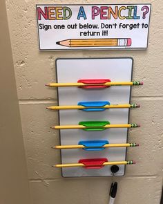 a bulletin board with pencils on it in front of a sign that says need a pencil?