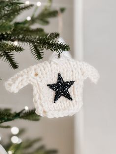 a crocheted sweater ornament hanging from a christmas tree