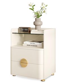 a white nightstand with two drawers and a vase on the top one has flowers in it