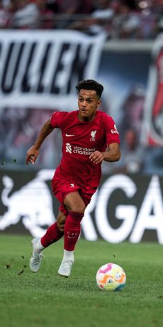 a soccer player is running with the ball in his hand as he looks to kick it