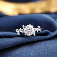 a diamond ring sitting on top of a blue cloth