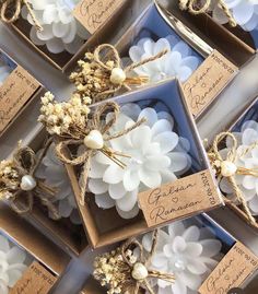 several boxes filled with white flowers and twine tied to each other on top of a table