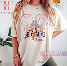 a woman standing in front of a wall wearing a t - shirt that says bride squad