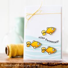 a card with two goldfishs on it and the words keep swimming printed on it