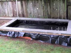 an empty pool in the middle of a yard with plastic covering it's sides